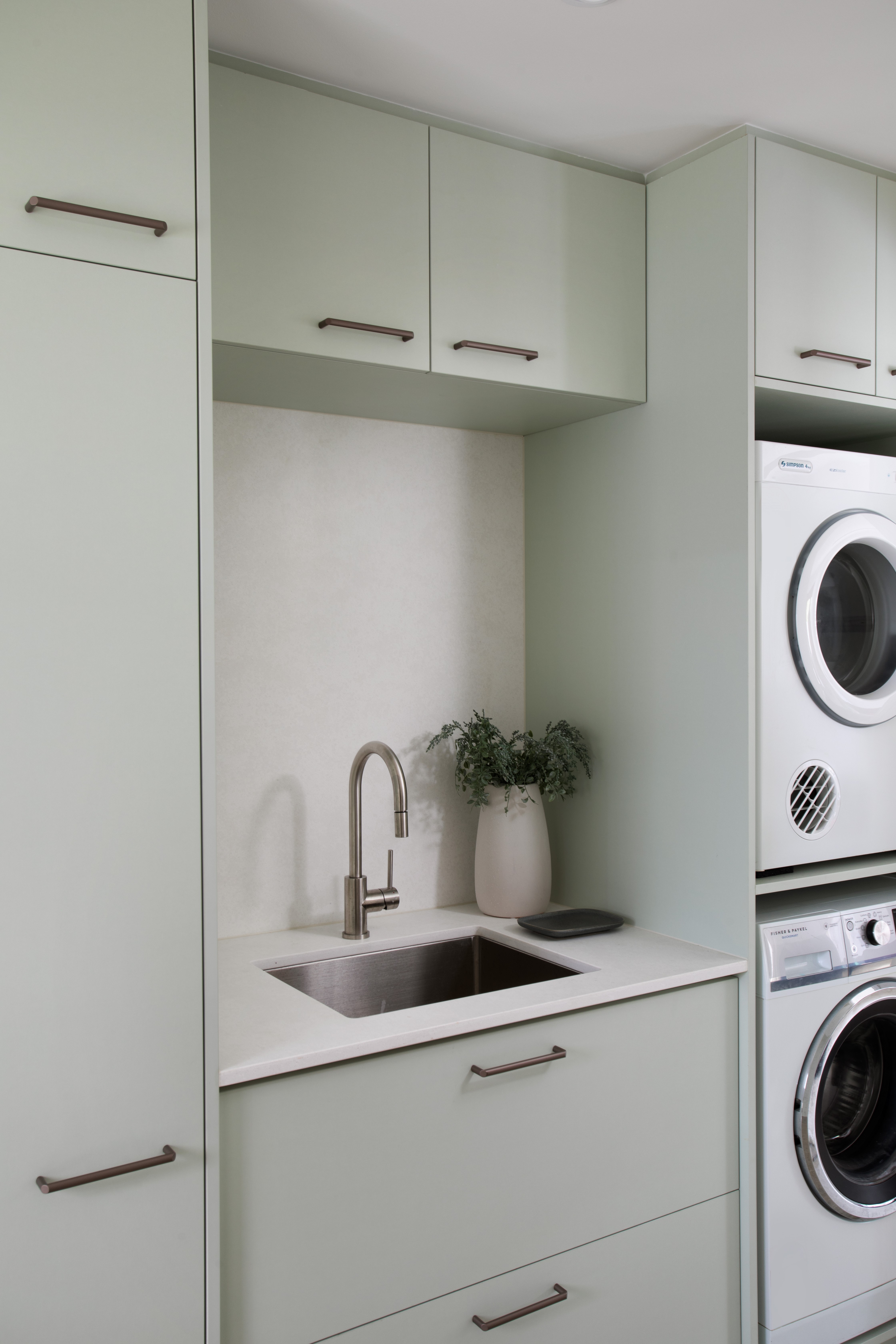  laundry room with light green cabinets